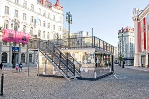 Výrazný prvek charitativní kavárny POTMĚ představuje zrcadlová fasáda z kompozitních hliníkových panelů albond, které odráží své okolí a kavárna se tak stává symbolicky neviditelnou.