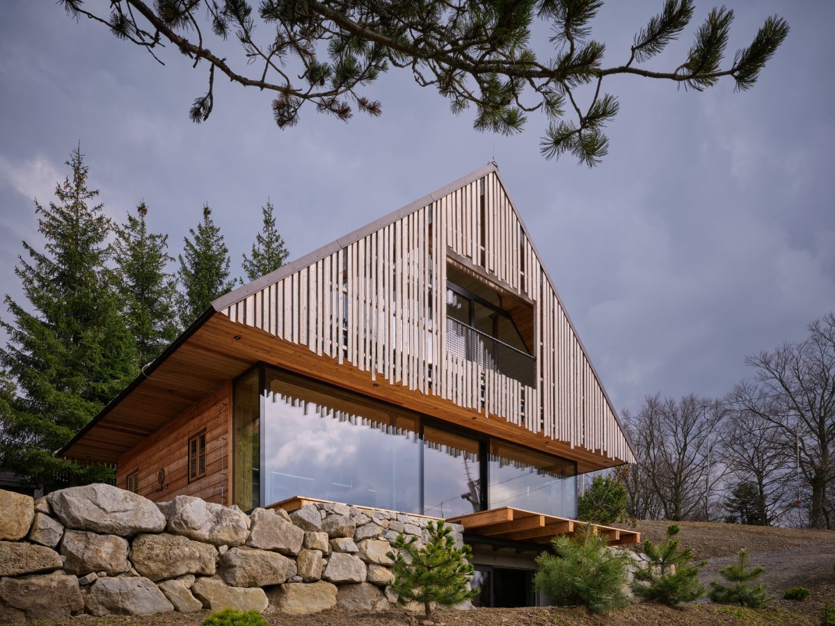 Směrem na východ se otevírá stěnami ze skla. (Chata Kohútka od SENAA architekti)