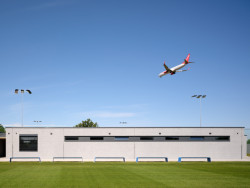 Divácká tribuna je krytá vykonzolovanou dřevěnou střechou, pod kterou je také kabina hlasatele s dobrým výhledem na celé fotbalové hřiště. (Sportovní areál SK Planá, PROAM ARCHITEKTI)