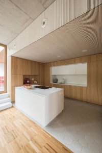 Pro interiéry domů byly zvoleny podobné materiály: pohledový beton, bílé omítky, dubové podlahy a vestavný nábytek v kombinaci bílého laku a přírodní dubové dýhy. (Trojdům, Martin Čeněk)