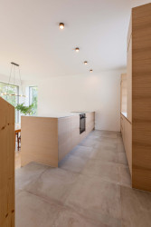 Kuchyně je oproti zbytku vyvýšená, přístavba totiž reaguje na terénní zlom. (Rodinný dům v Dehtárech, SP-AM)