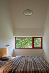 Bílou barvu v interiéru rozbíjí barevné rámy oken. (Rodinný dům v Řevnicích, 0,5 studio)