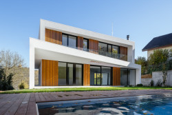 Zenová zahrada s bazénem na severní straně domu poskytuje prostor pro rodinné vyžití a odpočinek (Block House v Šáreckém údolí v Praze; Studio MA)