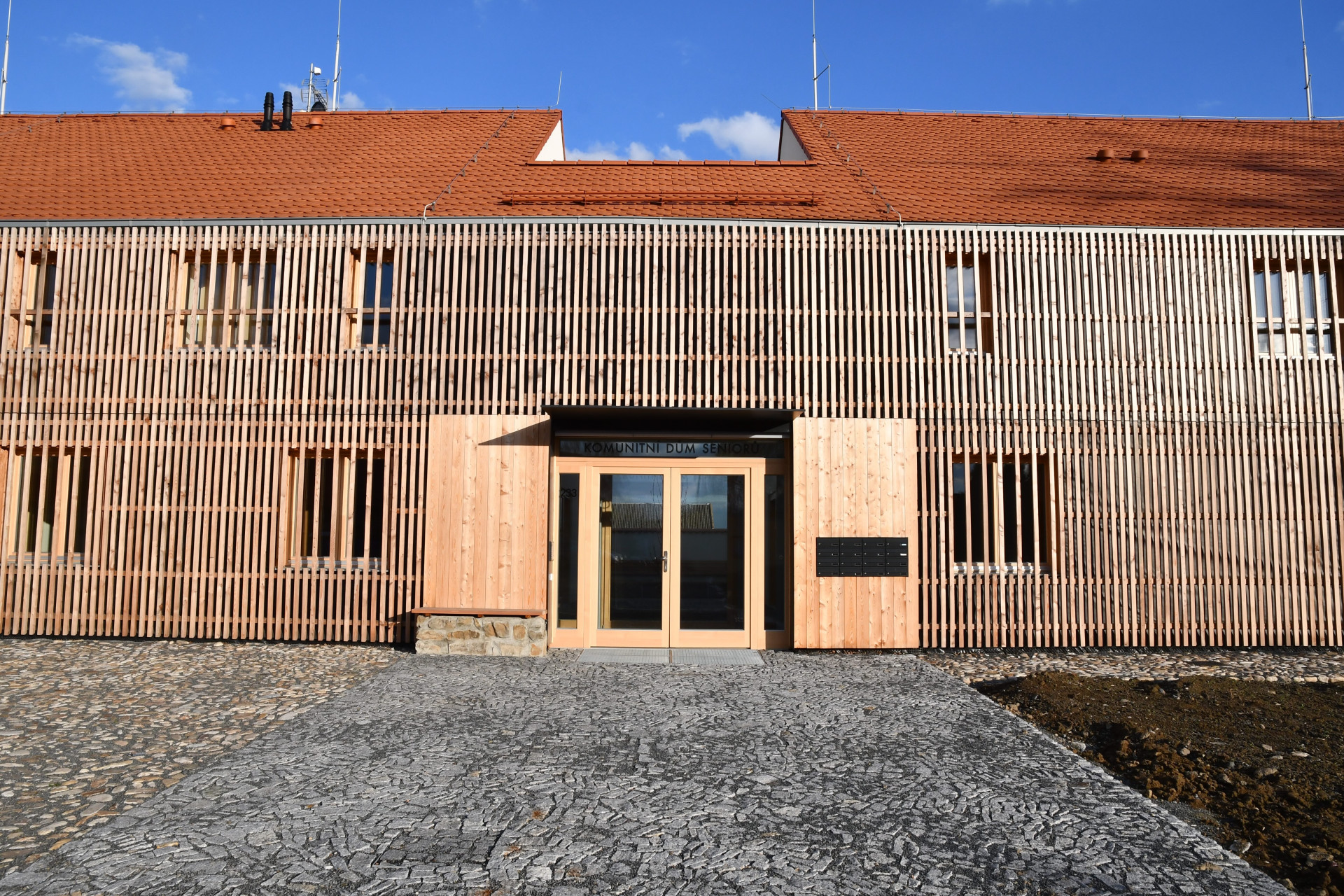 Komunitní dům pro seniory v Holasovicích, City Upgrade: Komunitní centrum pro seniory stojí ve středu ani ne dvoutisícových Holasovic, je novostavbou, ačkoliv původně mělo být vestavbou do starší stodoly