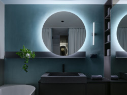 Výrazným prvkem koupelny je kruhové podsvícené zrcadlo. (Rekonstrukce bytu v Pitkovicích, Formafatal)