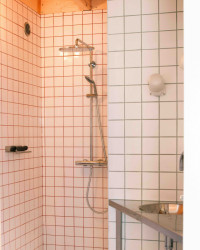 Vedle ložnice se nachází koupelna. Na první pohled je „jen“ bílá, na pohled druhý si všimnete různě barevných spár mezi kachličkami.