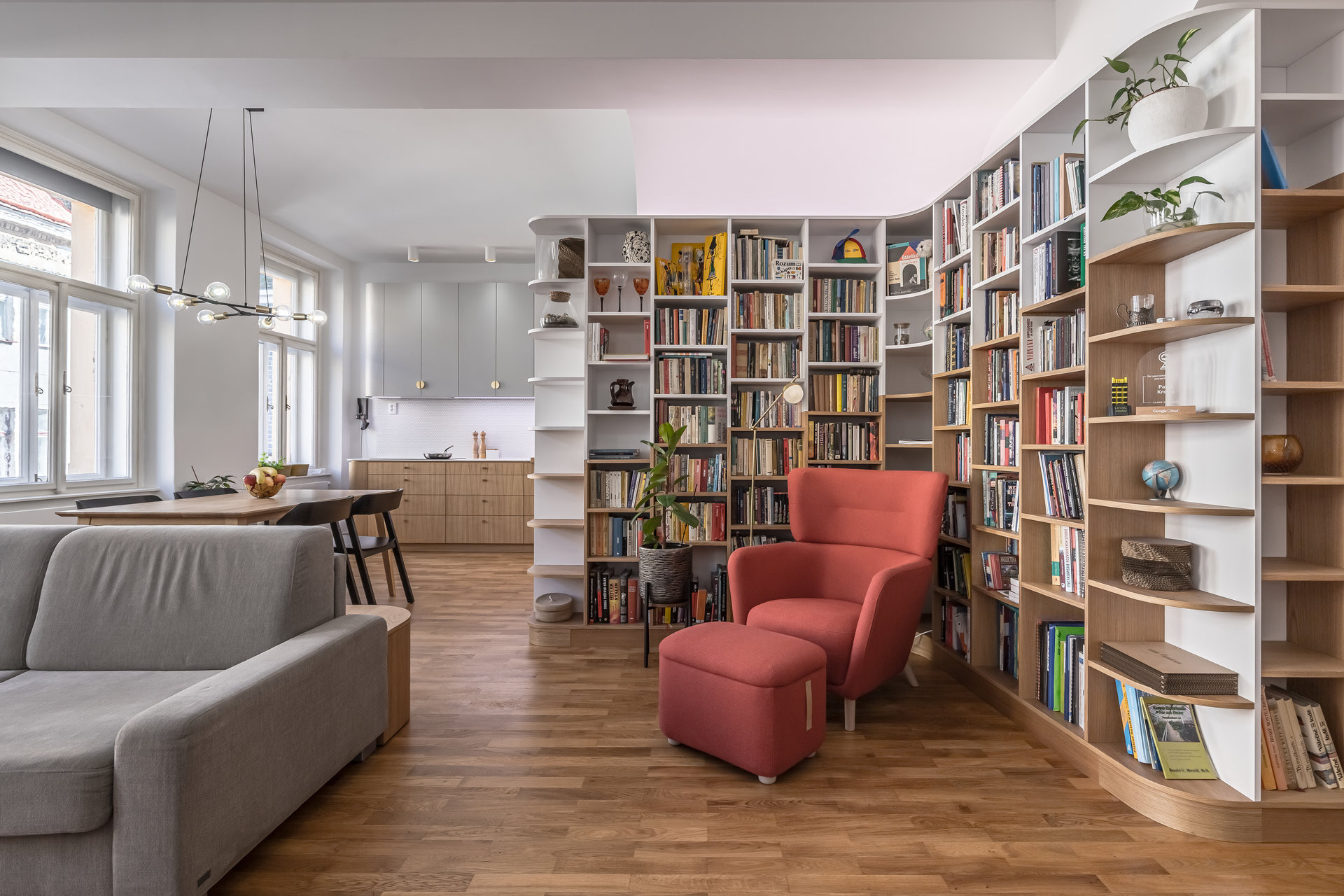 Útulná knihovna propojená s obývacím pokojem vytváří klidnou a intimní atmosféru. (Byt v Karlíně; momentura)