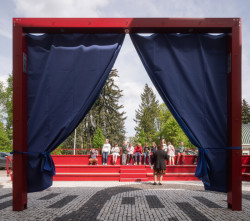 Kulturní prostor před ZUŠ Pečky od Alžběty P. Brůhové: Uprostřed prostoru stojí velká brána−portál, kterým se dá probíhat a při speciálních příležitostech na něj pověsit opona nebo promítací plátno