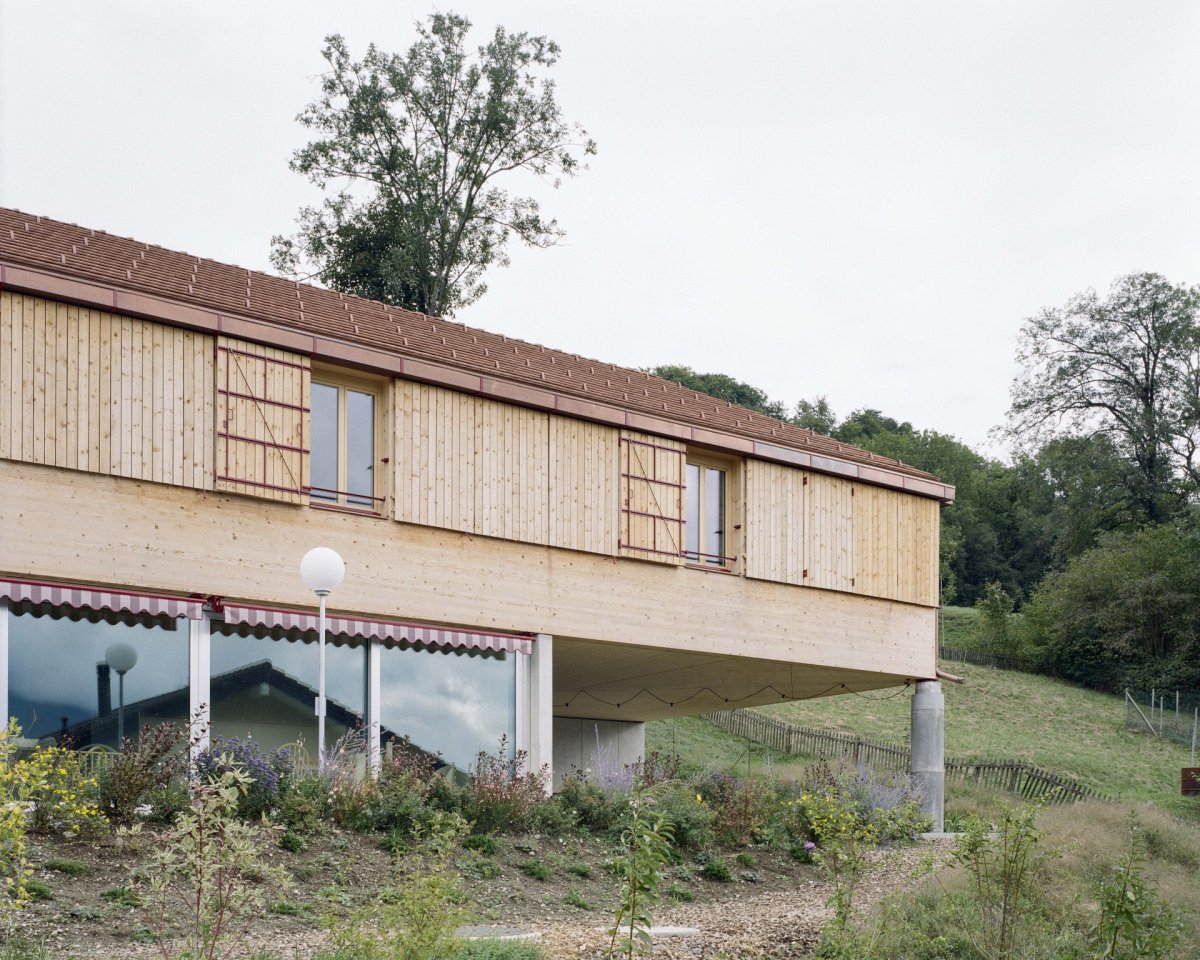 Rodinné komunitní bydlení ve Villy, Madeleine architectes, Studio François Nantermod: Fasáda si bere inspiraci z tvarosloví místní tradiční architektury, nepůsobí však jako pokus o jeho napodobení