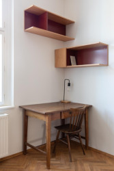 Psací stůl objevil klient na skládce, červené kovové police navrhly architektky na míru.  - Rekonstrukce bytu v Praze - Holešovicích, Studio Schwestern.
