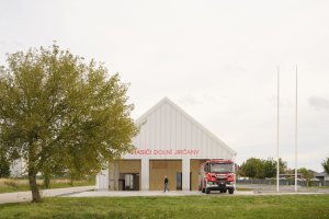 Velká budova je rozdělena na dvě zóny: garáž a vestavbu jako zázemí pro hasiče. (Hasičská stanice Dolní Jirčany, SOA architekti)
