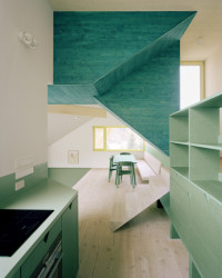 Dům ve svahu, AMUNT Nagel Theissen: Materiálově interiéru dominuje dřevo příjemných světlých odstínů zelené, žluté a jejich kombinací