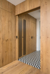 Rekonstrukce řadového domu u letiště, No Architects: Spojujícím znakem dřevěných prvků se stal dekor v podobě zrcadlově se opakujících diagonálních perforací ve dřevě a důmyslně provedený řemeslný detail