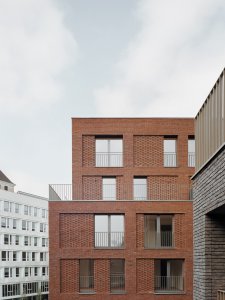 Studio AVENIER CORNEJO architectes navrhlo na břehu kanálu na předměstí Paříže obytný soubor třech domů s různým odstínem lícových cihel