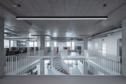 Městská knihovna v Praze na Petřinách, studio MONOM: Racionální charakter budovy podtrhují odhalené instalace na stropě.