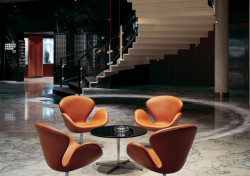 Lobby hotelu vévodí elegantní schodiště, výřez z dobové fotografie.