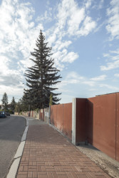 Betonový plot měl výšku těsně nad očima kolemjdoucích. Takovou vizuální bariéru bychom dnes nepochválili − ovšem jednotné provedení a červené branky jsou dobré pořád.