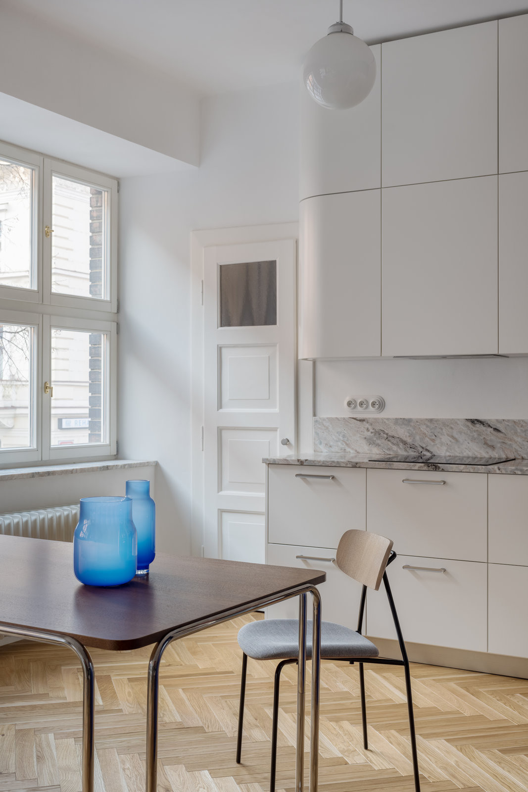 Pohled na jídelní stůl inspirovaný designem Marcela Breuera (Rekonstrukce bytu Žižkov, NOMAARCH)