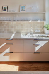 Několik kuchyňských skříněk nahradily police. Majitelé si na ně mohou pokládat oblíbené nebo často používané kusy nádobí. (Rekonstrukce bytu ve Strašnicích, MENU architekti)