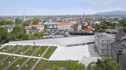 Architekti dali novostavbě podlouhlý půdorys, vytvořili tak veřejný prostor chráněný před ruchem dopravy. (Interaktivním centru pohádek a animace OKO v Bílsko-Bělé v Polsku, Nizio Design International)