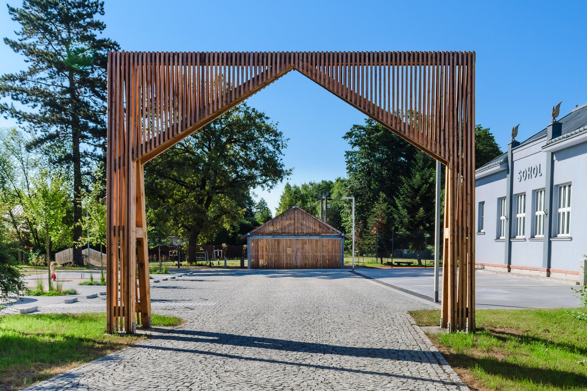 Nová vstupní brána symbolicky definuje novou náves. (Příšovická náves, atakarchitekti)