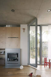 Do hlavního obytného prostoru ústí kuchyň, knihovna, krb a oddělitelné schodiště. (Rodinný dům v Radotíně, Papundekl architekti)