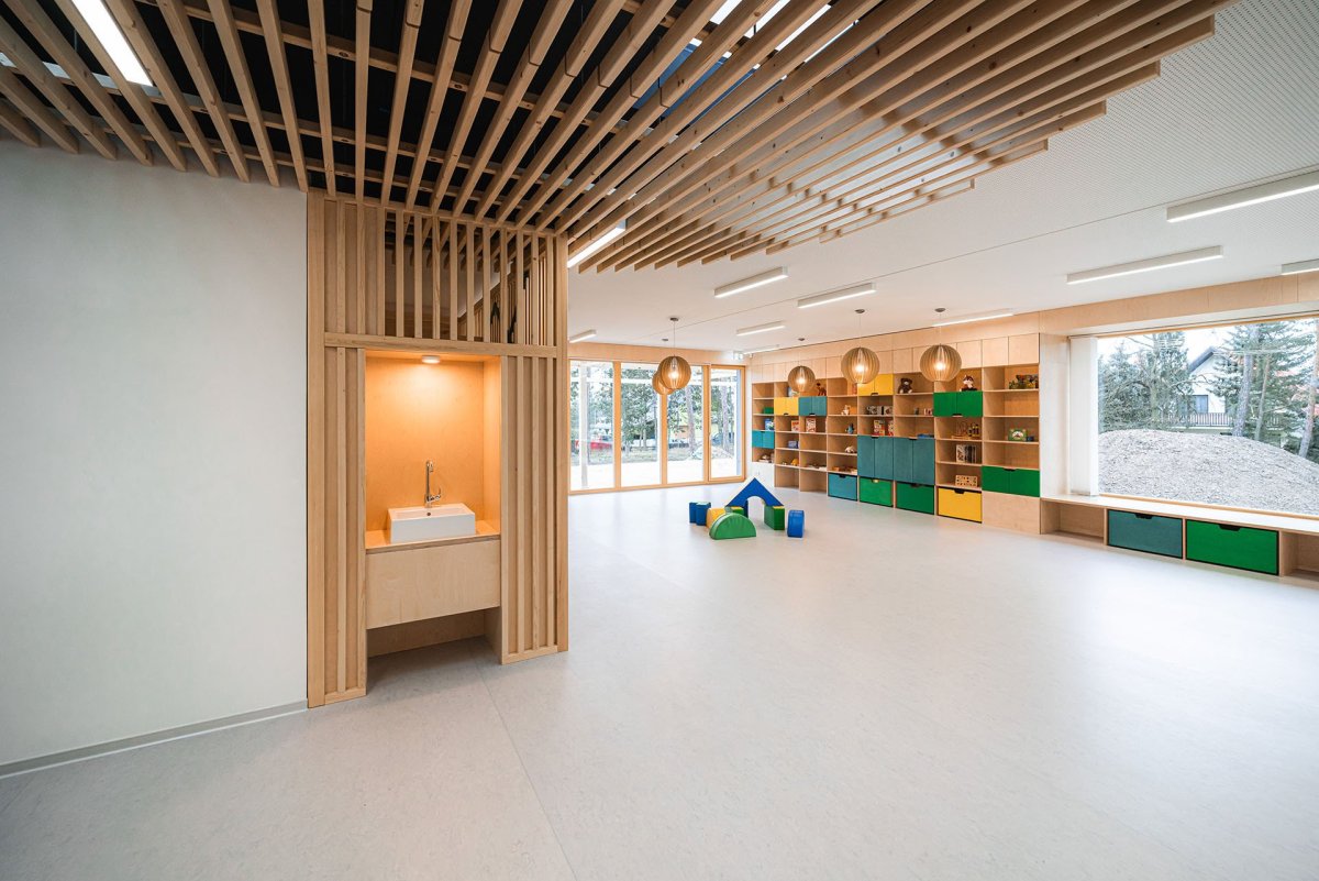 Interiér je měkký, organický, dřevěný. (Mateřská škola ve Vědomicích, Architip)