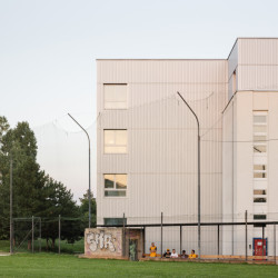 Nové hmoty jsou opláštěné trapézovým plechem, jasně se tak odlišují od původních bílých omítkových fasád. Tento kontrast a jasné oddělení nového od staršího porota ocenila. (ZŠ v Devínské Nové Vsi, Martin Hudec, Katarína Bergerová)