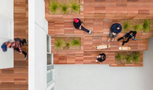 Nájemníci mohou odpočívat a užívat si otevřený prostor dvora společně s dalšími mladými lidmi. (Rose Apartments v Los Angeles, Brooks & Scarpa)