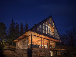 V suterénu maskuje velké okno kamenná podezdívka, pod střechou zase dřevěné latě. (Chata Kohútka od SENAA architekti)