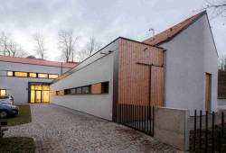 Knihovna ve Šlapanicích, Milan Podroužek a spolupracovníci: Stavba na půdoryse ve tvaru písmene L se skládá ze dvou podlouhlých hmot – jedné jednopodlažní a druhé dvoupodlažní