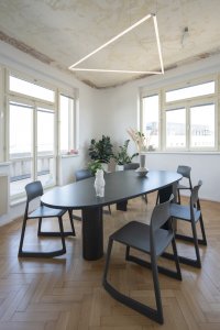 Masivní stůl v zasedací místnosti navrhli architekti a architektky ze studia COSMO. - Kanceláře marketingové agentury KHS v Praze, studio COSMO