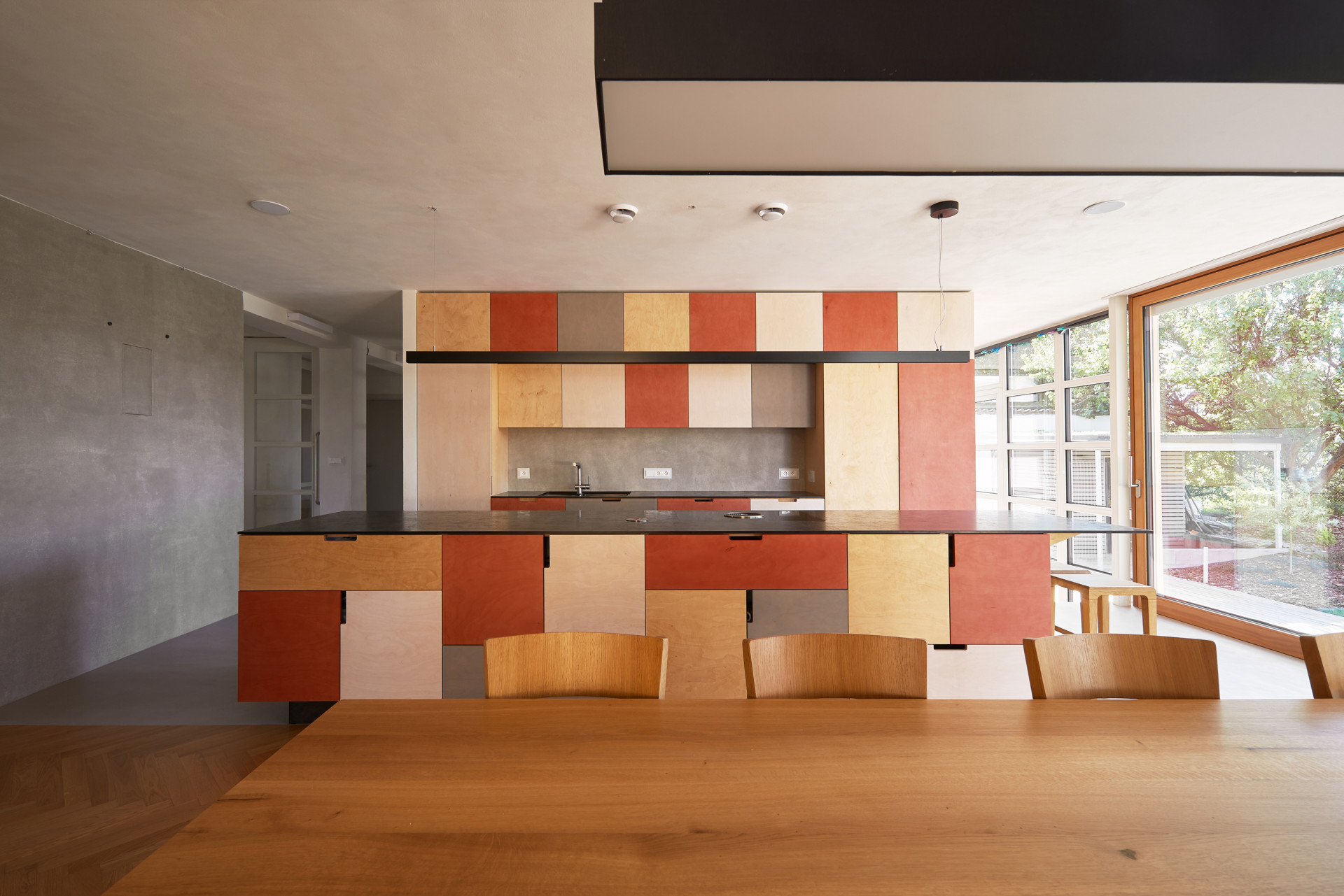 Dům v Ostopovicích, ORA: Architekti a architektka říkají, že si v domě hráli s rastry a barvami. Kuchyně je barevná, navržená z březové překližky