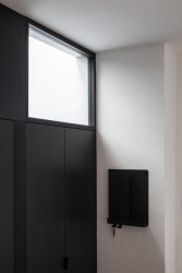 Půdní byt s černým boxem, Komon architekti: Kontrast černé a bílé