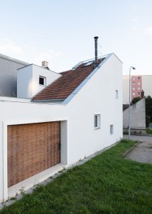 Původně slepá stěna dostala tři malá okna a průřez do dvorku, který je jinak celý obehnaný stěnami. (Rodinný dům v Kohoutovicích, Ateliér Kopecký)