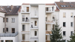 Vertikální směr zdůrazňuje také konstrukce, na níž jsou zavěšené balkony, a výtahová šachta.