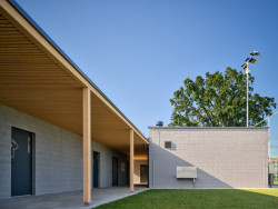 Čtyři samostatné objekty vizuálně i provozně propojuje dřevěné loubí. (Sportovní areál SK Planá, PROAM ARCHITEKTI)