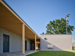 Čtyři samostatné objekty vizuálně i provozně propojuje dřevěné loubí. (Sportovní areál SK Planá, PROAM ARCHITEKTI)