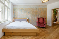 Byt v Praze-Vinohradech, Archistroj a Atelier HORIZONT: Stěnu v ložnici pokrývá zrestaurovaná proškrabovaná omítka