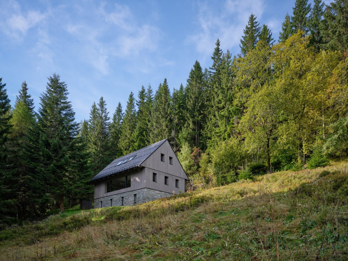 Velkoformátové okno směřuje dolů ze svahu. (Chalupa Na Kukačkách; edit! architects)