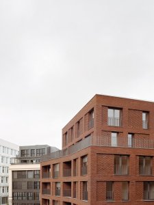 Studio AVENIER CORNEJO architectes navrhlo na břehu kanálu na předměstí Paříže obytný soubor třech domů s různým odstínem lícových cihel