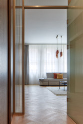 Podlahy jsou ze světlého dřeva poskládané v tradiční „stromečkové“ skladbě. (Byt Masna, Iva Hájková Studio)