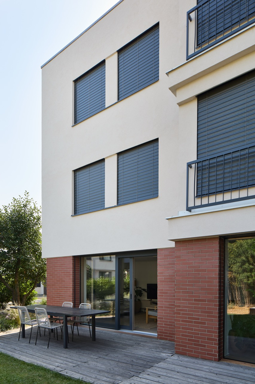 Balkony zmizely, zato vznikl nový portál do zahrady. (Řadový dům v Čimicích, Plus One Architects)