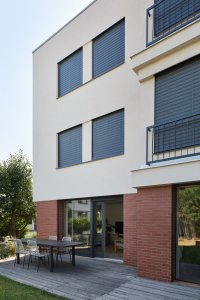 Balkony zmizely, zato vznikl nový portál do zahrady. (Řadový dům v Čimicích, Plus One Architects)