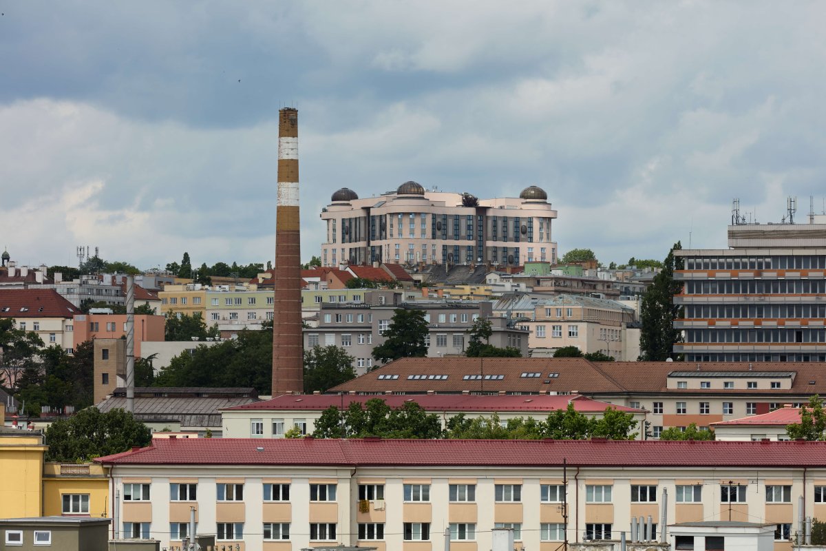 Ještě víc než fasáda vadila jeho velikost. „Neadekvátní měřítko poškozující horizont“ a „mizerná proporce“, tak to pojmenoval architekt Burian ve zmíněné anketě. Mohutná krychle je skutečně k vidění z mnoha míst – zde pohled ze tři kilometry vzdálených Strašnic.