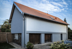 Rodinný dům v Písnici, daviddavidová architekti: Původní stodola je nově šedě omítnutá, vrátily se na ni také lizénové rámce