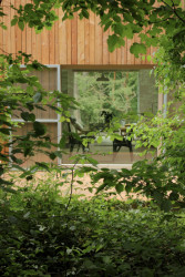 System Recovery Architects - Domek mezi lesy: Velké posuvné okno spojuje přízemí s terasou