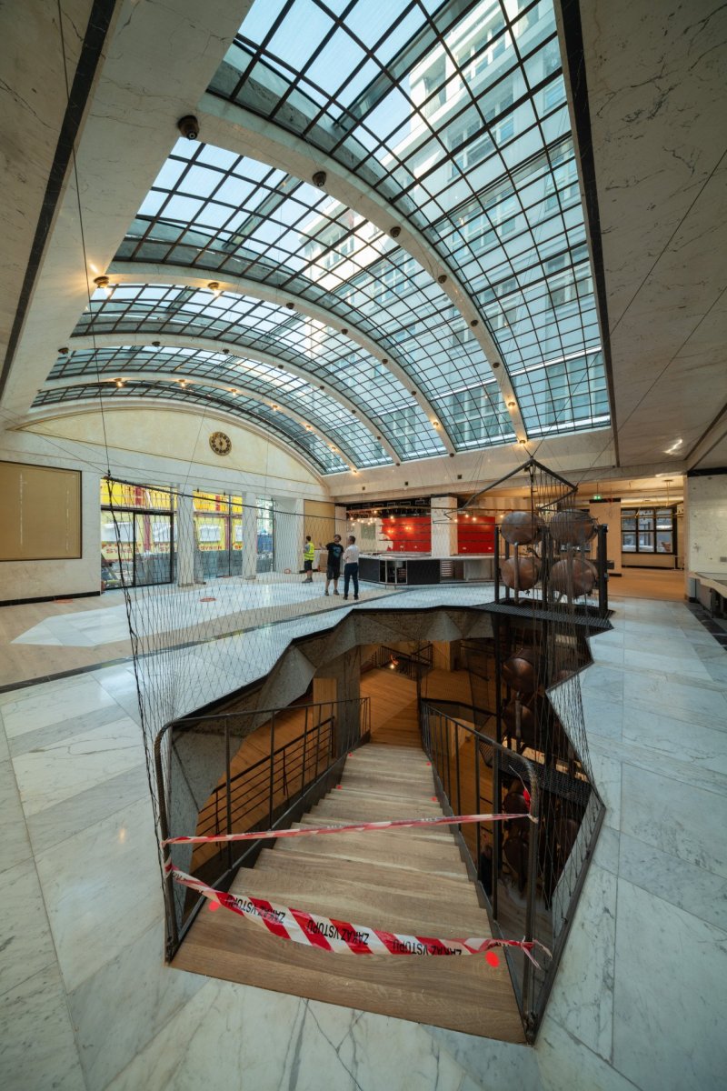 Podlahu bankovní haly přímo pod obnovenou klenbou proto prořízl nepravidelný otvor s geometricky řešenými stěnami. (Fotografie z průběhu realizace restaurace Červený Jelen)