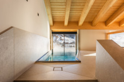 Vstup do bazénu z interiéru spa Hotelu Damelis. Prosklené posuvné dveře umožňují proplavat do venkovní části bazénu. 