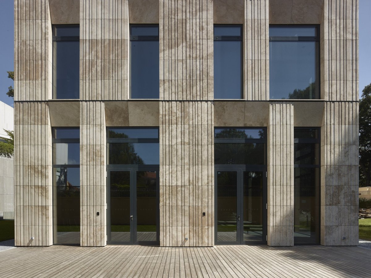 Rekonstrukce a dostavba Korejského velvyslanectví v Praze, SIAL architekti a inženýři spol. s r.o.: Fasádu přístavby tvoří travertinový obklad s vertikálním kanelováním